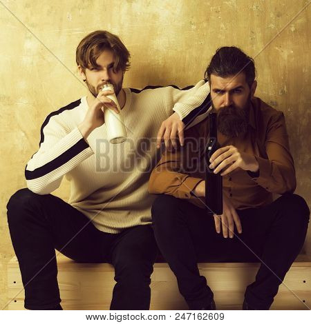Different Views On Life. Friends In Casual Wear Sitting With Bottles On Beige Wall. Handsome Man Wit