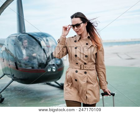 Business woman near private helicopter