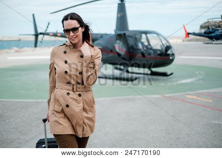 Business woman near private helicopter