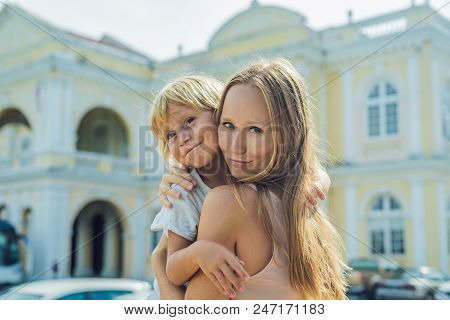 Mom And Son On Background Of Old Town Hall In George Town In Penang, Malaysia. The Foundation Stone 