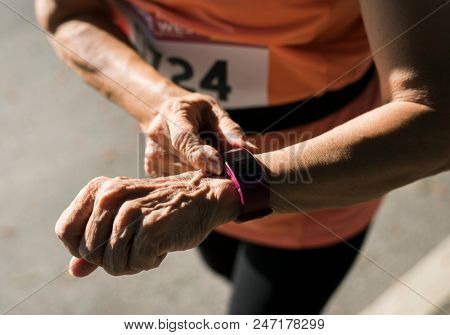 Senior runner using a fitness tracker