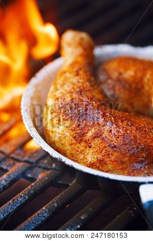 chicken legs spiced by special spice blend on bbq grill with flame