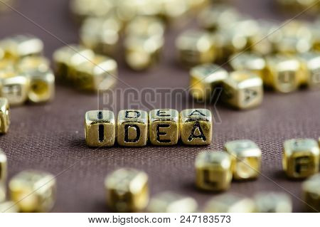 Word Idea Made From Small Golden Letters On The Brown Background, Selective Focus