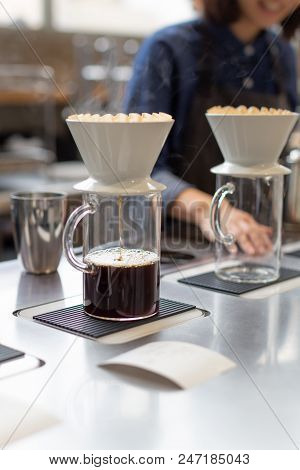 The Proccess Of Hand Dripping Coffee In The Coffee Shop. Barista On The Background.
