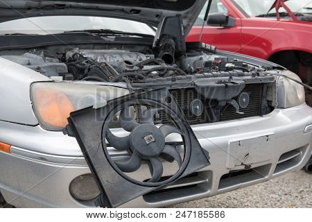 The Engine Compartment Of A Wrecked Car Reveals Missing Parts, Inlcuding The Bumper, The Radiator An