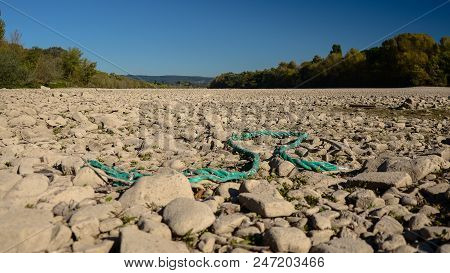 Dry Riverbed On A Nice Autumn Day With Visible Trees And Broken Turquoise Rope.
River Rhine In Germa