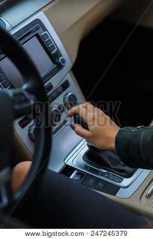 Girls Hands Are Aestetically Situated On The Transmission To Shift Gear Of A Grey Car.