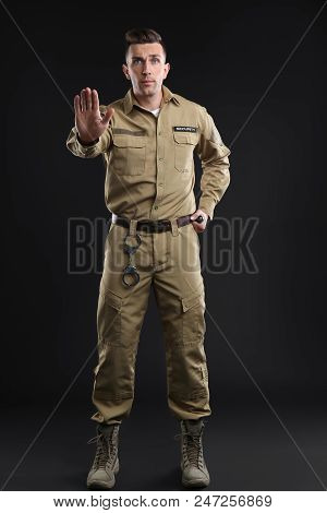 Male Security Guard With Police Baton On Dark Background