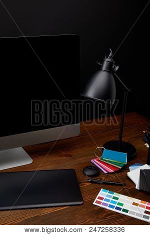 Close Up View Of Graphic Designer Workplace With Colorful Pallet, Blank Computer Screen, Lamp And Gr
