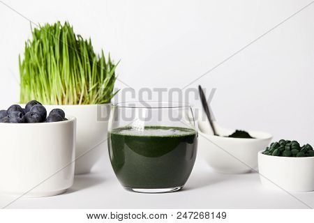 Spirulina Smoothie, Spoon, Cups With Spirulina Grass And Blueberries, Bowls With Spirulina Powder An