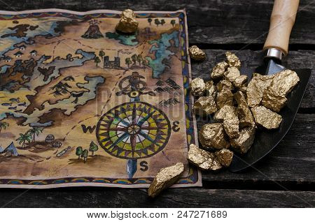 Treasure Map And Shovel Full Of Gold Nuggets Ore On Wooden Table. Treasure Hunter Or Gold Miner Conc