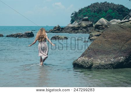 Handsome Girl On The Beach Background. Portrait Of A Woman In White Clothes On The Sea