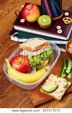 Concept Of School Lunch Break With Healthy Lunch Box Full Of Sandwiches, Banana, Apples And School S