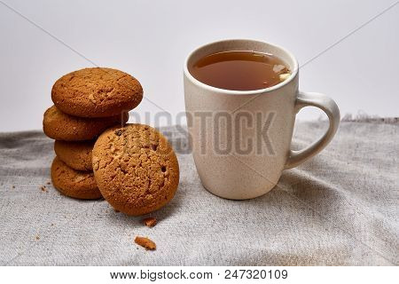 White Porcelain Mug Of Black Tea Or Earl Grey And Pile Of Sweet Cookies On Homespun Napkin Over Whit