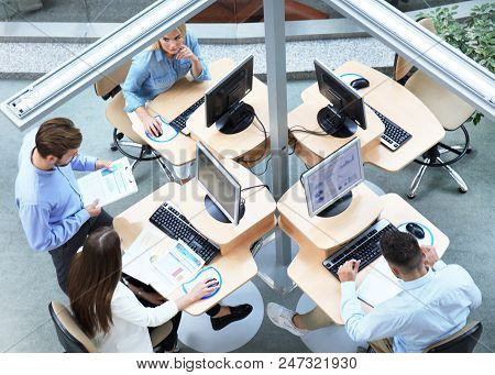 Top View Of Young Modern Colleagues In Smart Casual Wear Working Together While Spending Time In The