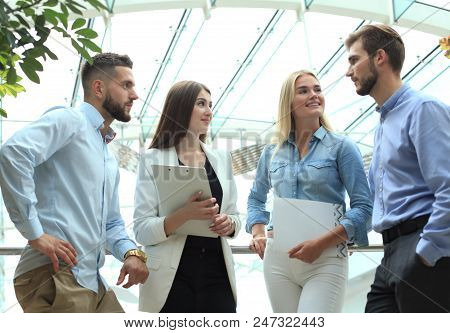Young Modern Colleagues In Smart Casual Wear Having A Brainstorm Meeting While Standing In The Creat