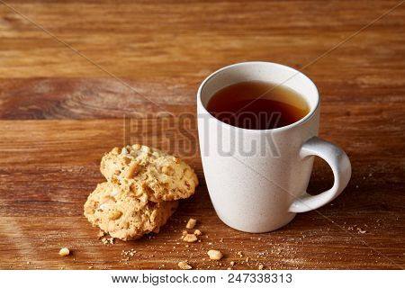 White Porcelain Mug Of Black Tea Or Earl Grey And Pile Of Sweet Cookies On Rustic Wooden Background,