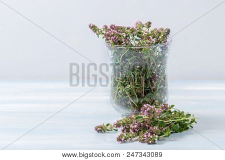 flowering oregano in a glass on a wooden table
