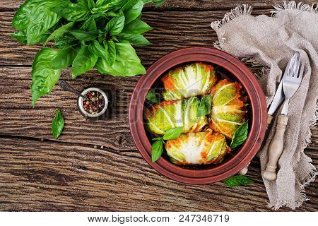 Cabbage Rolls Stuffed With Rice With Chicken Fillet In Tomato Sauce On A Wooden Background. Tasty Fo