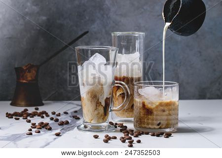 Iced Coffee Cocktail Or Frappe With Ice Cubes And Pouring Cream In Three Different Glasses With Vint
