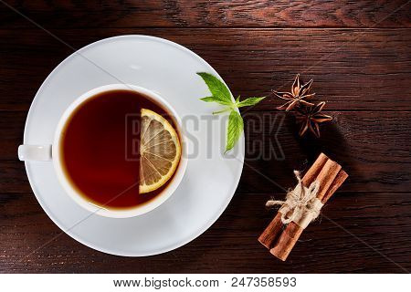 Looking Down On A Cup Of Tea Hot Beverage With Cinnamom, Mint Leaves And Fruits Of Star Anise.