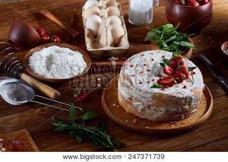 Strawberry Tart Covered With Whipped Sour Cream Surrounded By Organic Ingredients Over Wooden Backgr