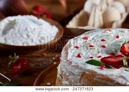 Strawberry Tart Covered With Whipped Sour Cream Surrounded By Organic Ingredients Over Wooden Backgr