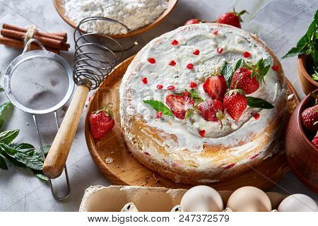 Strawberry Tart Covered With Whipped Sour Cream Surrounded By Organic Ingredients Over White Backgro