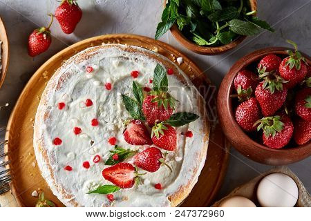 Strawberry Tart Covered With Whipped Sour Cream Surrounded By Organic Ingredients Over White Backgro