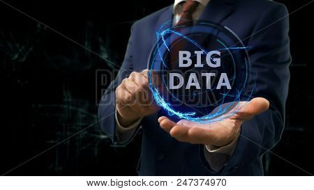 Businessman Shows Concept Hologram Big Data On His Hand. Man In Business Suit With Future Technology