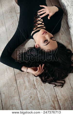 Above View Of Beautiful, Sexy Brunette Woman In Black Lying On Floor, Seductive Touching Decolte. Pr