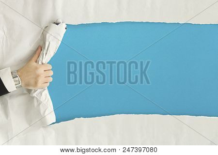Male Hand Ripping A Paper Sheet Revealing A Blank Blue Surface
