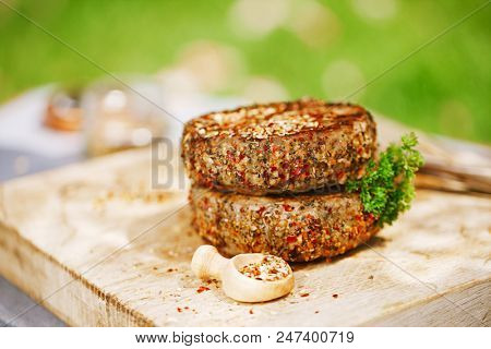 lamb burgers spiced by mint and lamb rub on wooded board