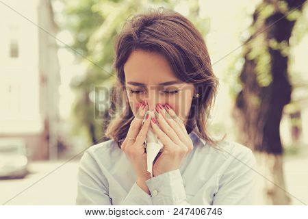 Young Woman With Allergy Symptoms Blowing Nose