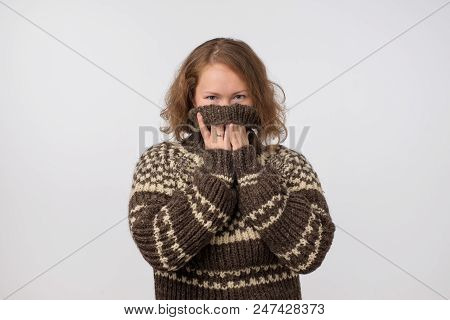Woman In Warm Brown Sweater Hiding Her Face. Only Eyes Are Seen. She Wants To Stay Anonym. Fear Of P