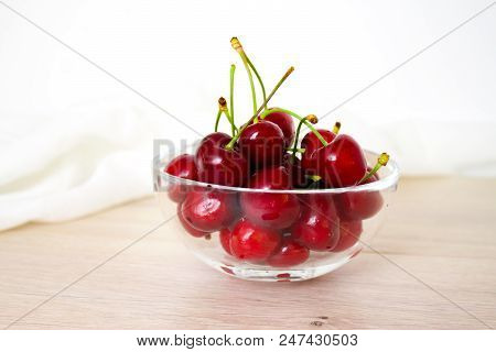 Healthy Eating And Food Concept - Cherries In Glass Dish. Cherry On Wood And White Background.