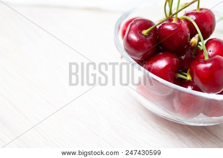 Healthy Eating And Food Concept - Cherries In Glass Dish. Cherry On Wood And White Background.