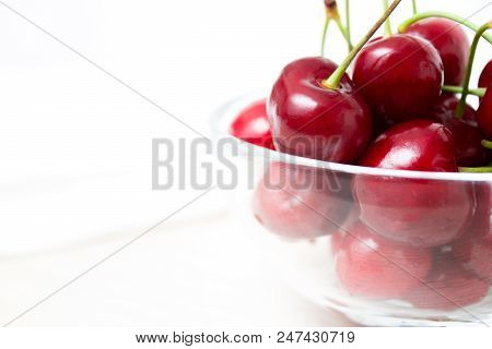 Healthy Eating And Food Concept - Cherries In Glass Dish. Cherry On Wood And White Background. Close