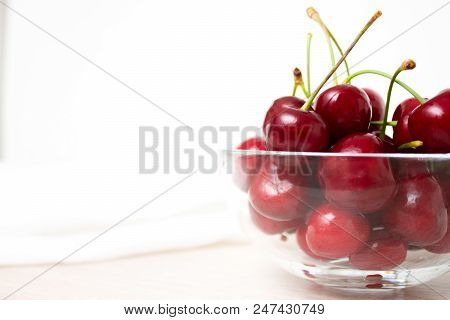 Healthy Eating And Food Concept - Cherries In Glass Dish. Cherry On Wood And White Background. Close