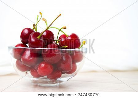 Healthy Eating And Food Concept - Cherries In Glass Dish. Cherry On Wood And White Background.