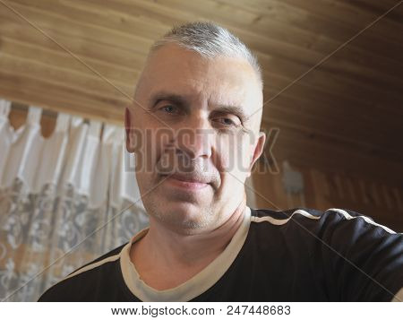 Indoor Head And Shoulders Portrait Of A Sneering Man