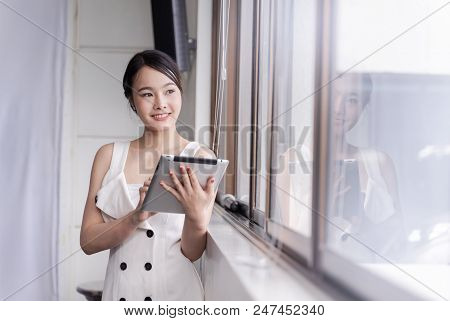 Modern business woman stainding with tablet in the office, copy space.