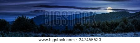 Panorama Of Carpathian Mountains At Night In Full Moon Light. Beautiful Landscape With Forested Hill