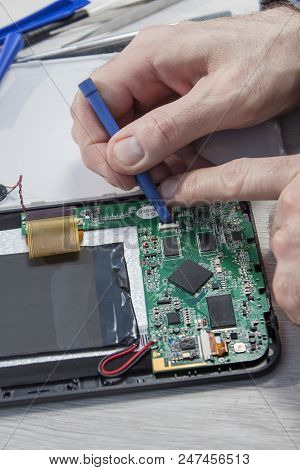 The Electronic Service Employee Unscrews The Broken Tablet.
