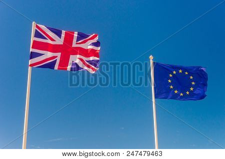 British Flag And European Flag Waving Against Blue Sky In Wimereux, France.