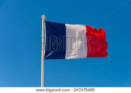 French Flag Waving Against Blue Sky In Wimereux, France.