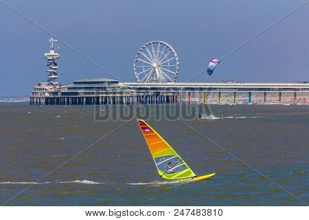 Scheveningen, The Hague, The Netherlands - June 27 2018: Speeding Windsurfers Sailing Off The Beach 