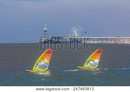 Scheveningen, The Hague, The Netherlands - June 27 2018: Speeding Windsurfers Sailing Off The Beach 