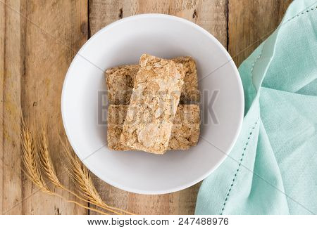 Wheat Biscuit Cereal In Bowl On Rustic Wooden Table, Top View Photo