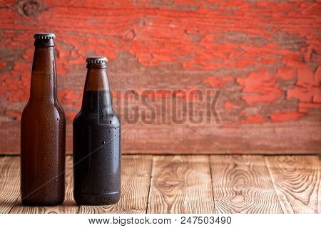Two Unlabelled Ice Cold Beer Bottles Of Different Shapes, One With A Long Neck And The Other Short, 